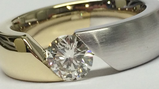 Ein Spannring, zweifarbig, mit einem einzelnen, großen Brillanten